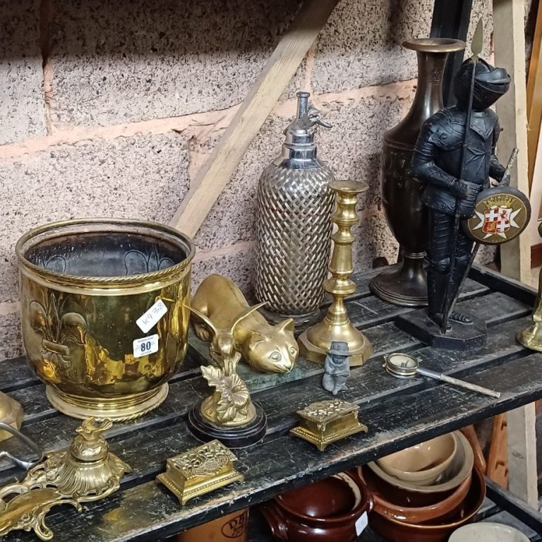A shelf of brass and iron objects for interior design sourcing service